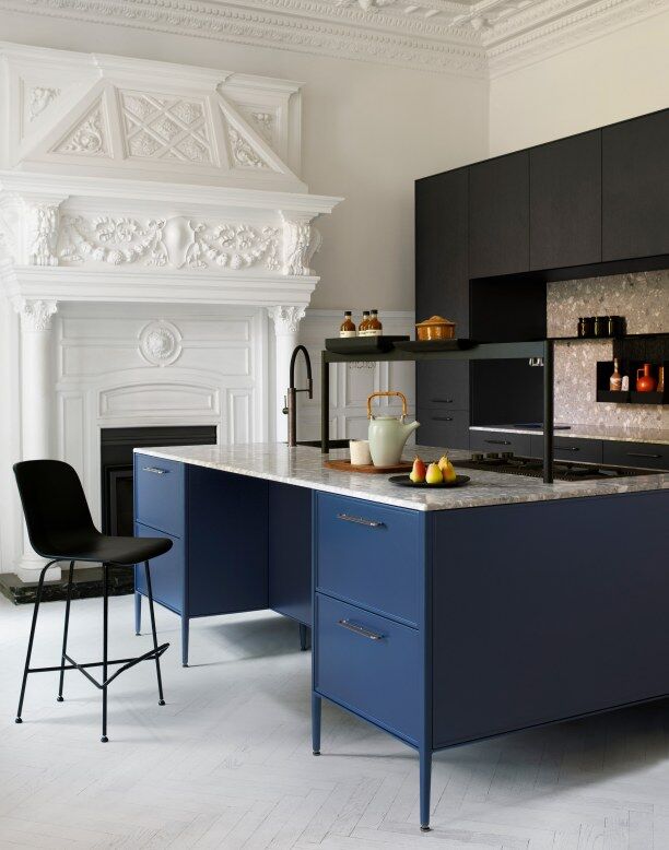 Cuisine luxueuse avec éléments en bleu et comptoir en marbre.